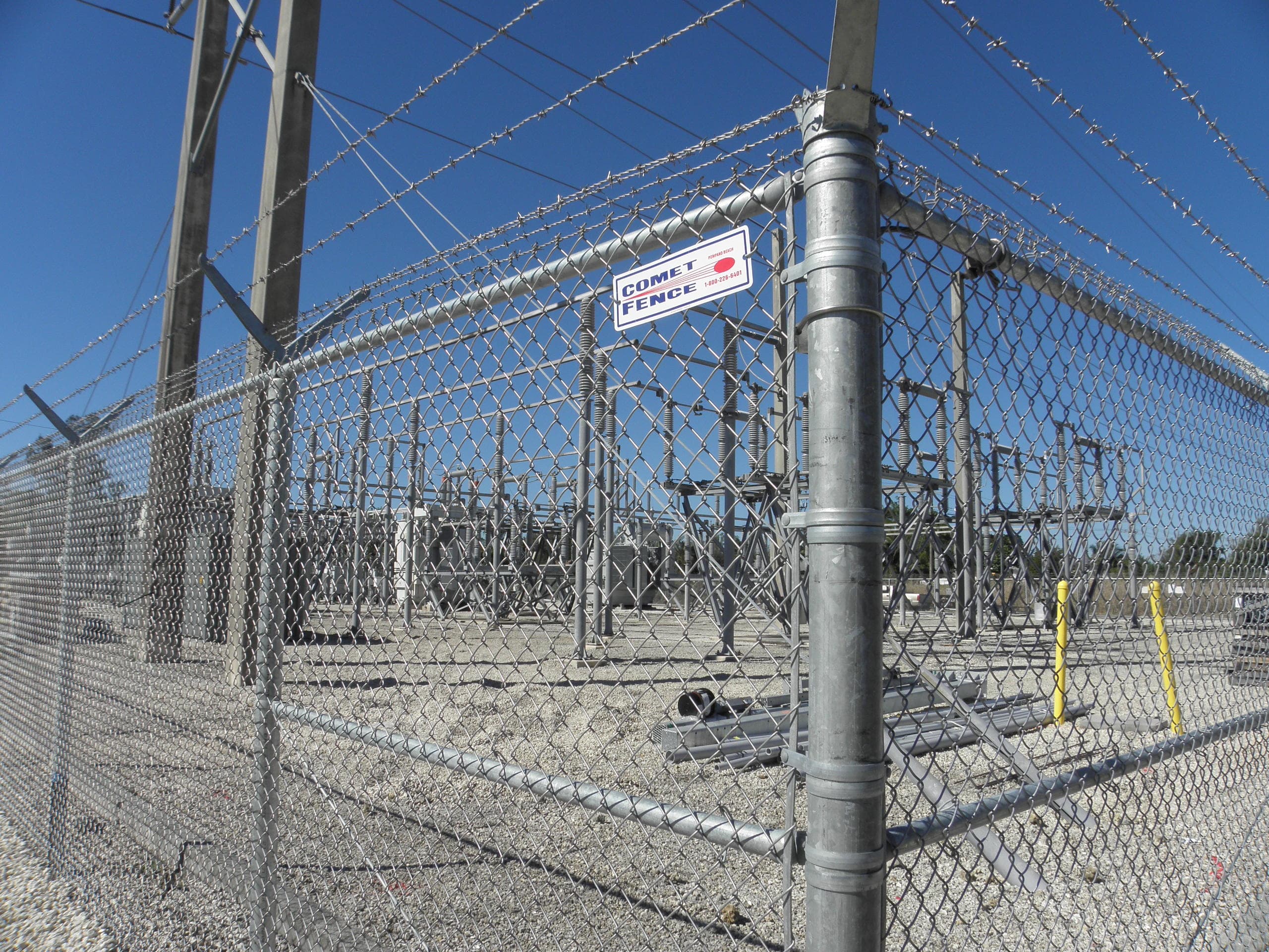 Chain link fence line with wooded background