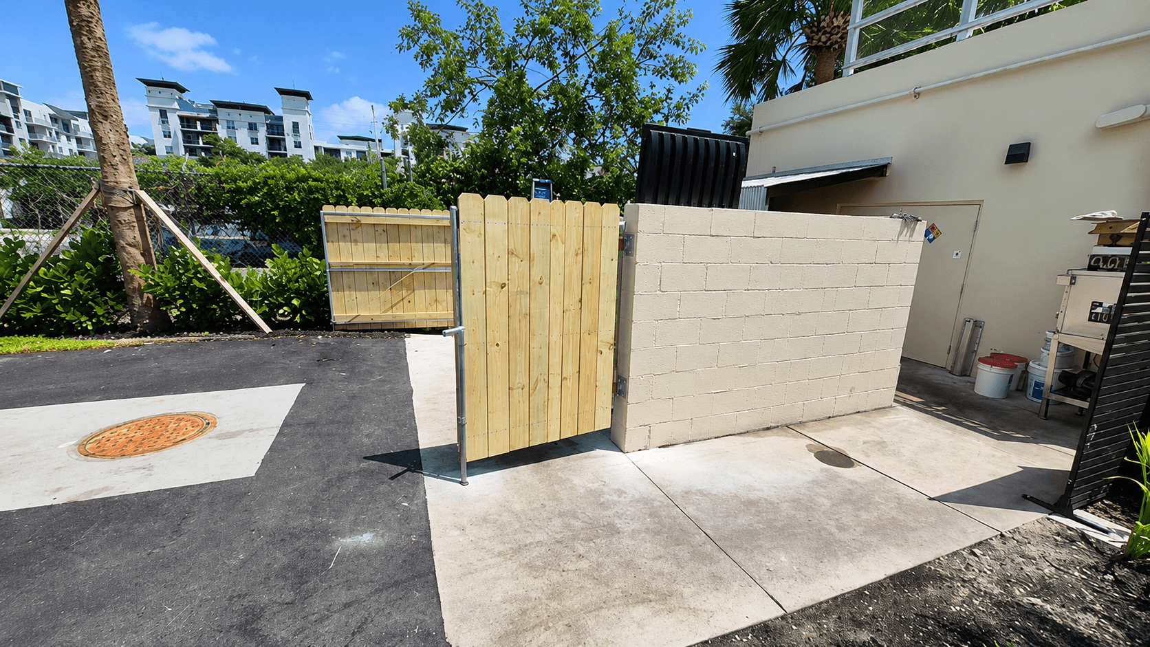 Wood service gate beside a block wall at a multi-family property