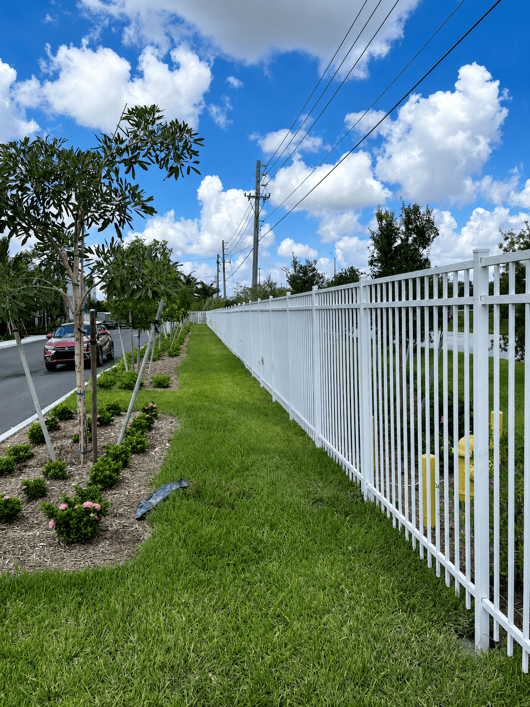 Long white picket perimeter fence along a grass frontage