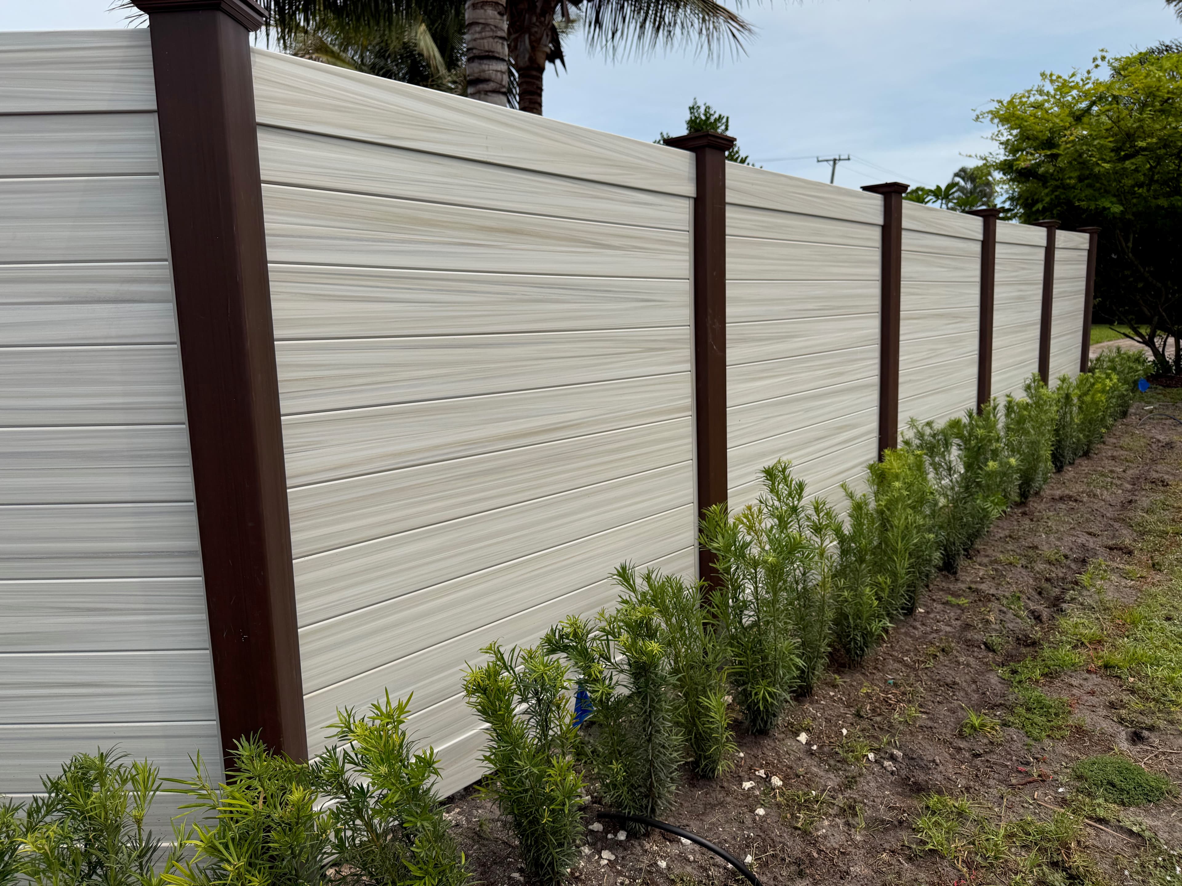 Modern horizontal privacy fence with light panels and dark brown posts