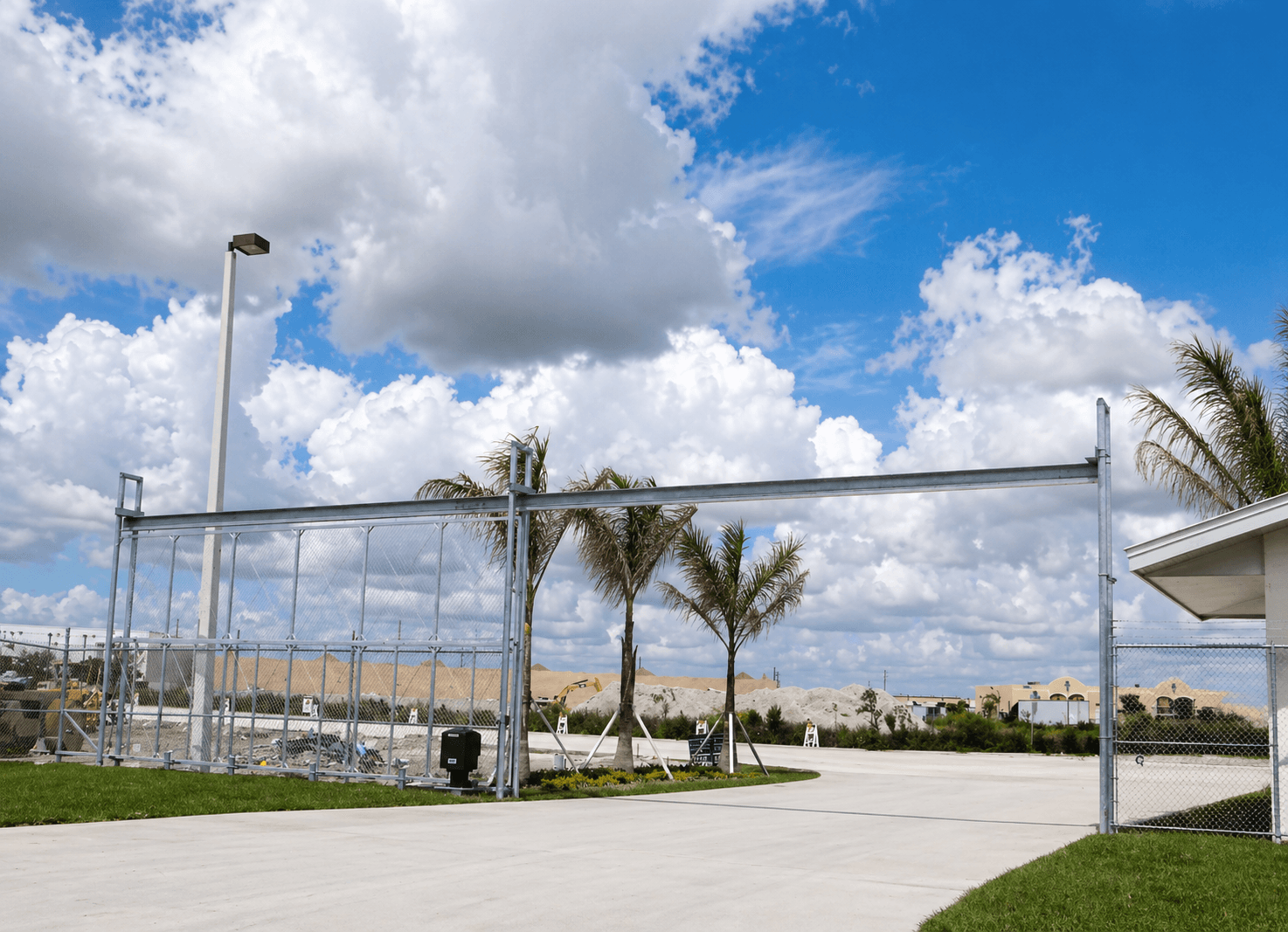 Rolling security gate closing a commercial yard opening